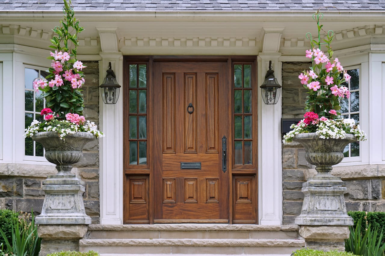 Custom wooden entry door installation with decorative planters by Glass and Door Pro in Charlotte, NC